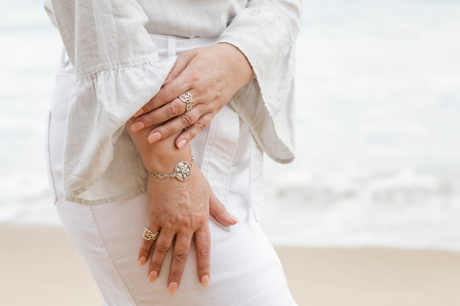 Close-up of Anne's hand adorned with the Baltic Amulet Bracelet and Legacy Cuff Rings. 